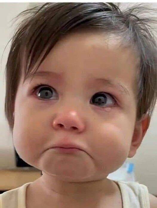Foto de perfil triste de un bebé con ojos llorosos