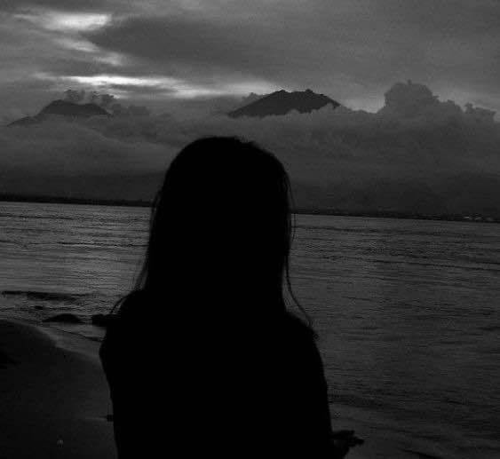 Foto de perfil de silueta triste en la playa al atardecer