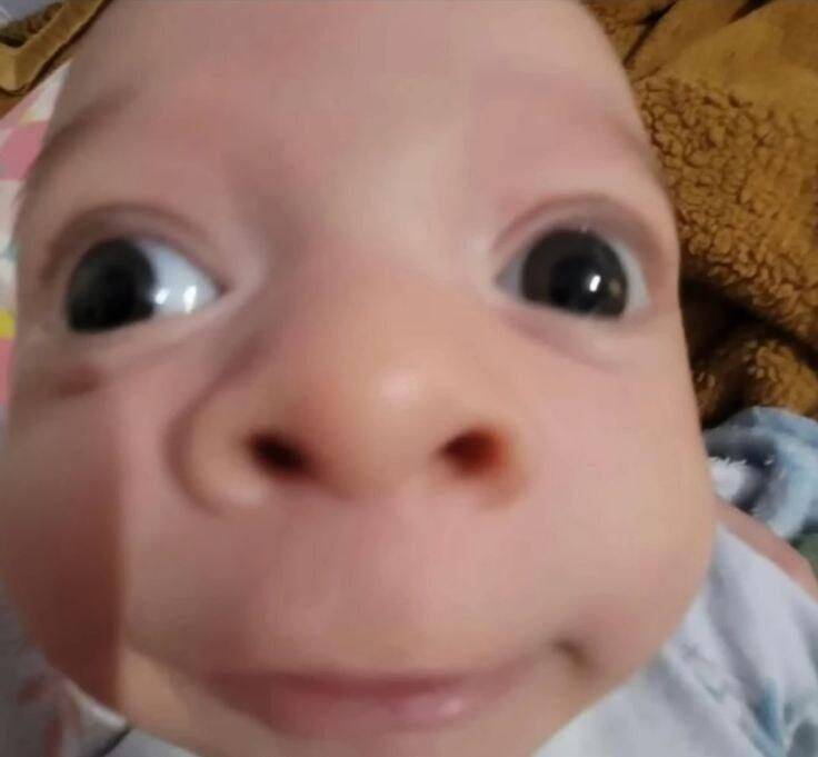 Divertida foto de perfil de un bebé con los ojos muy abiertos
