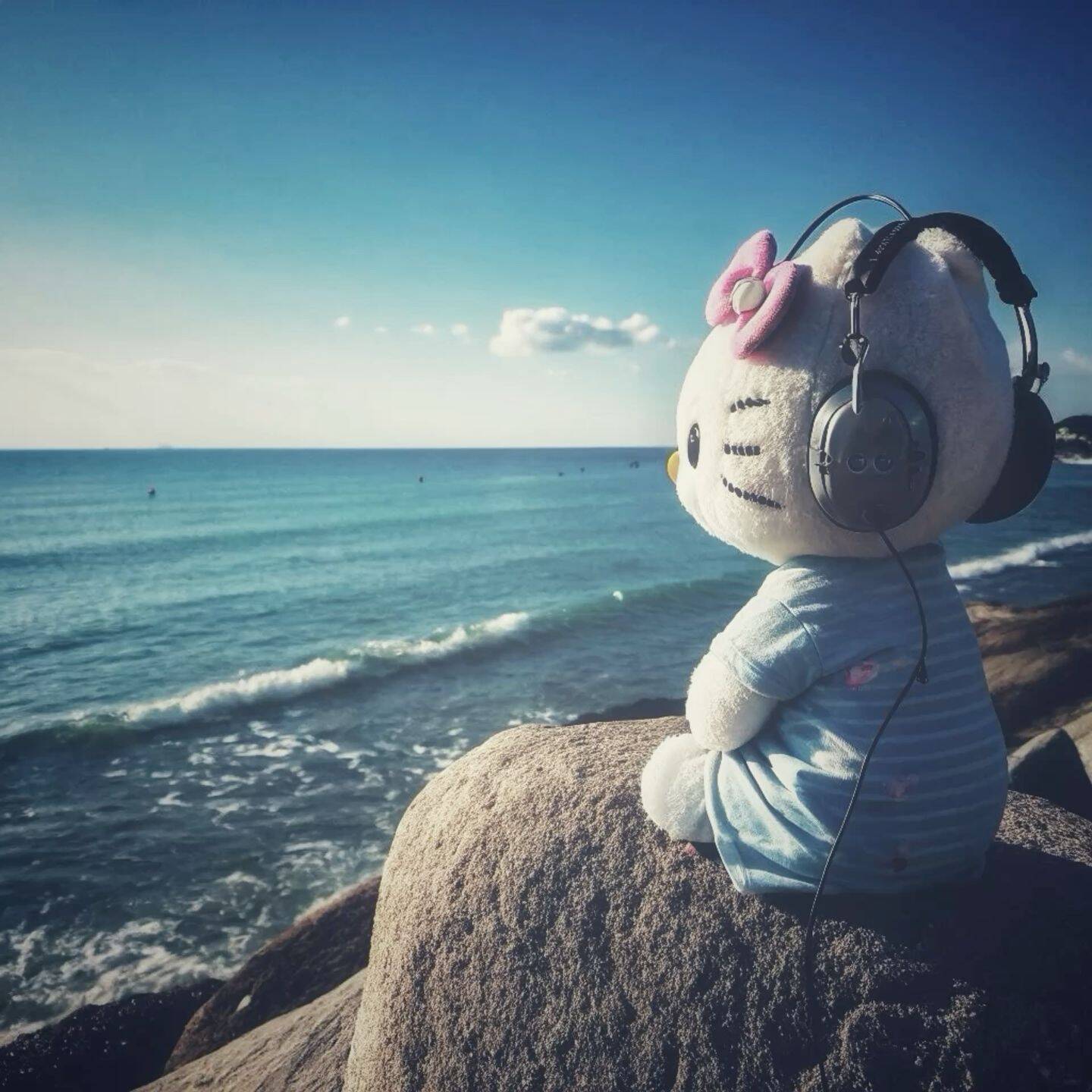 Foto de Perfil da Hello Kitty Relaxando na Praia com Fones de Ouvido