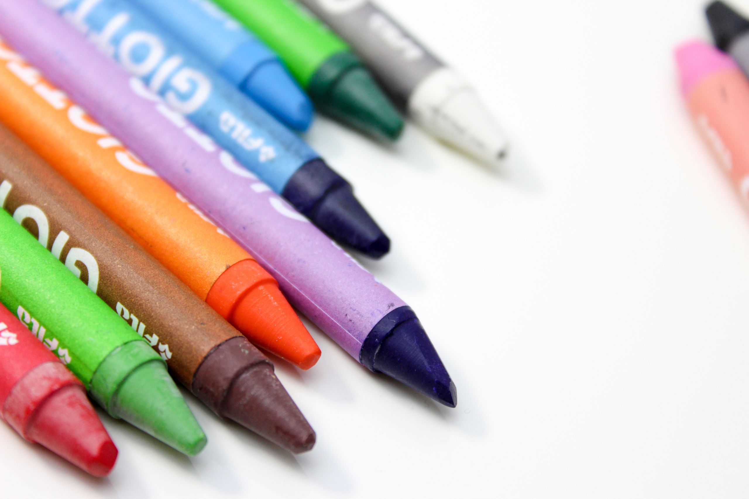 Un primer plano vibrante de crayones variados dispuestos sobre un fondo blanco.