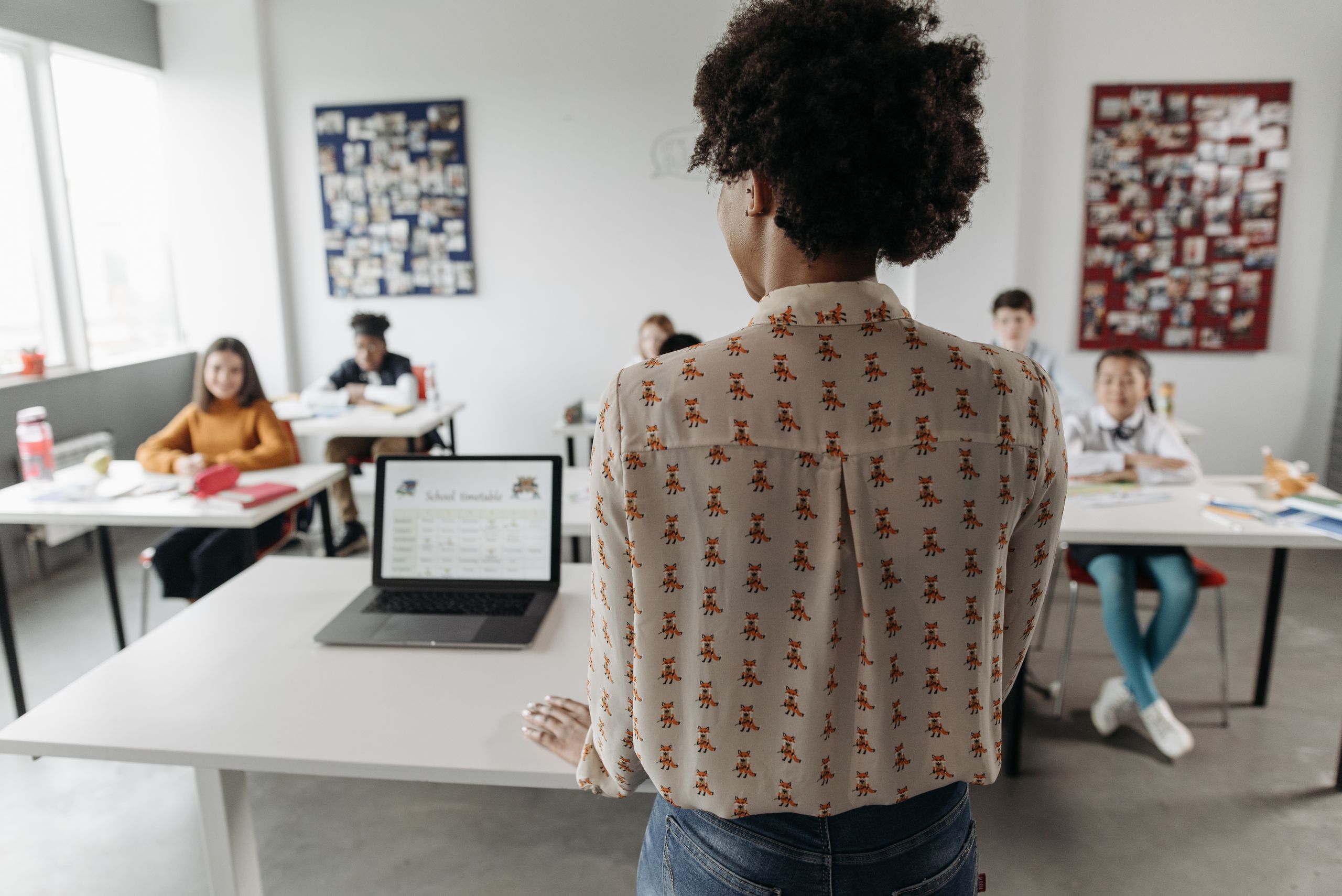 Profesora que involucra a los estudiantes en un salón de clases con estudiantes diversos.